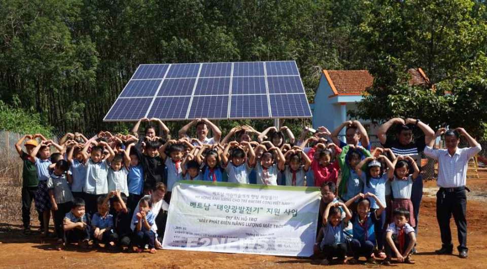 ▲에너지나눔과평화가 독립형 발전시스템을 지원한 베트남 통낫학교 어린이 및 교사들이 태양광 설비 앞에서 기념촬영을 하고 있다.