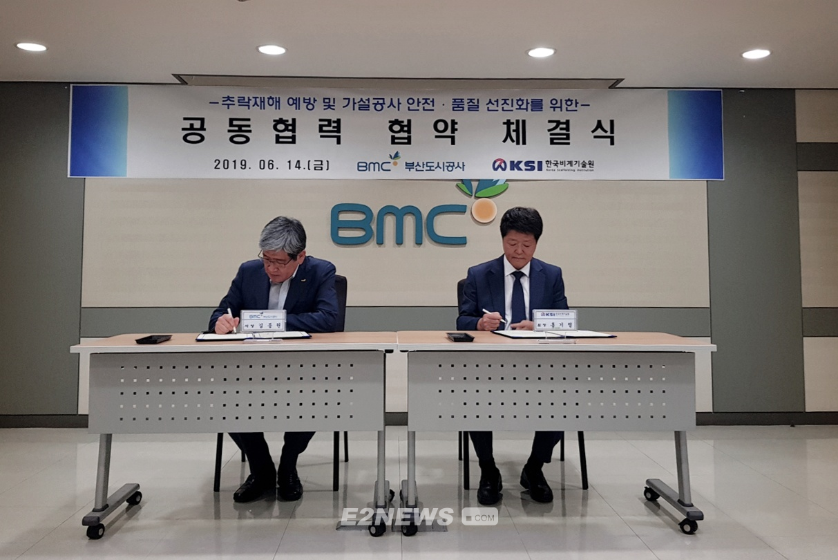 ▲김종원 부산도시공사 사장(왼쪽)과 홍기철 비계기술원장이 협약서에 서명하고 있다.