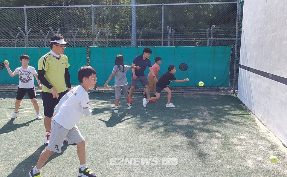 ▲가스공사 통영기지본부 테니스 동아리 회원들이 학생들에게 기본자세를 가르치고 있다.