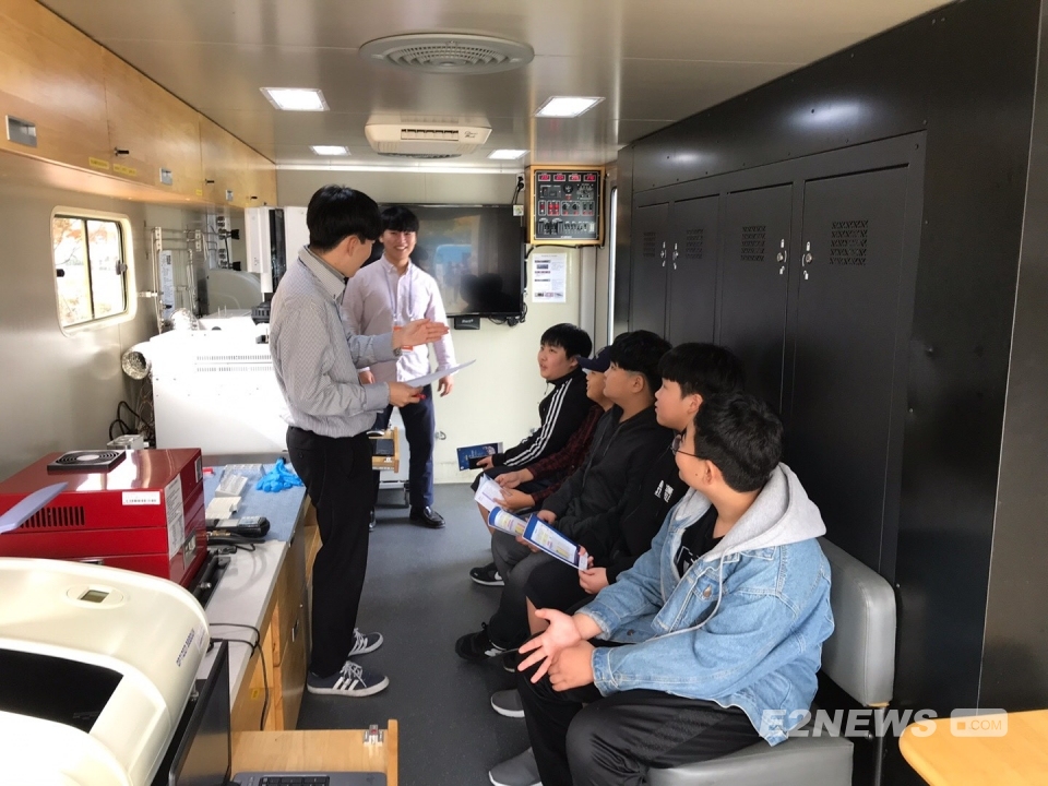 ▲한국석유관리원 직원들이 이동시험실차량 내에서 학생들에게 운영 방법을 설명하고 있다.
