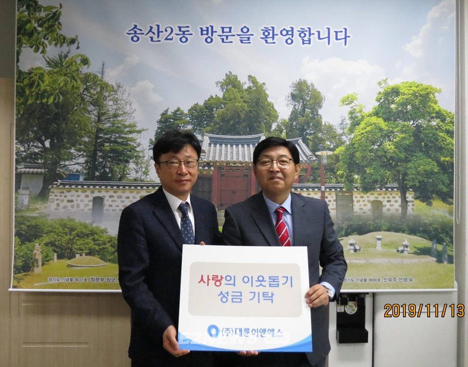 ▲전동수 대륜이엔에스 대표이사(오른쪽)가 홍정길 송산2동 행정복지센터 국장에게 성금증서를 전달하고 있다.