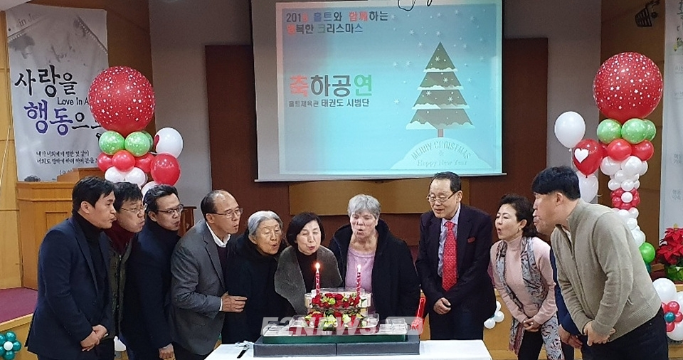 ▲홀트 크리스마스 축하파티 행사에 참여한 대성 김영대 회장(오른쪽 네 번째)과 참석자들이 축하케잌 촛불을 끄고 있다.