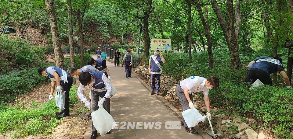 ▲대륜이엔에스 직원들이 등산로 주변에 버려진 쓰레기를 수거하고 있다.
