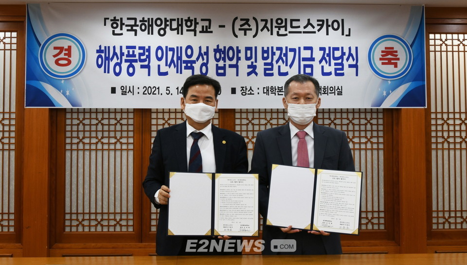▲도덕희 한국해양대학교 총장(왼쪽)과 이용우 지윈드스카이 대표가 업무협약식을 마치고 협약서를 들어보이고 있다.