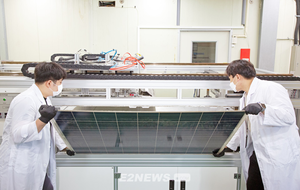 ▲연구원들이 유리를 분리·회수하기 위해 태양광 폐패널을 개발장치에 넣고 있다.