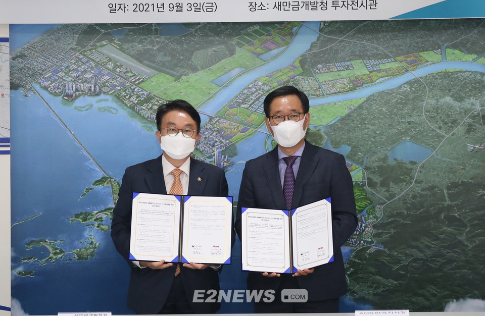 ▲양충모 새만금개발청장(왼쪽)과 김규정 AON 한국지사장이 협약식을 마치고 협약서를 보여주고 있다.