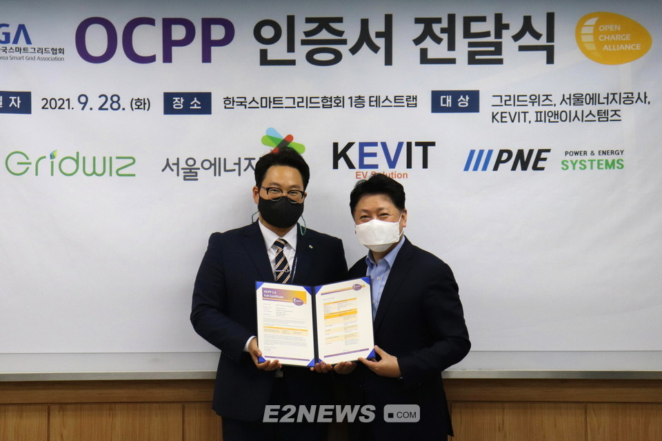 ▲유호연 서울에너지공사 스마트그리드부 부장(왼쪽)이 전기차충전기 관제시스템에 대한 OCPP인증서를 받고 있다.