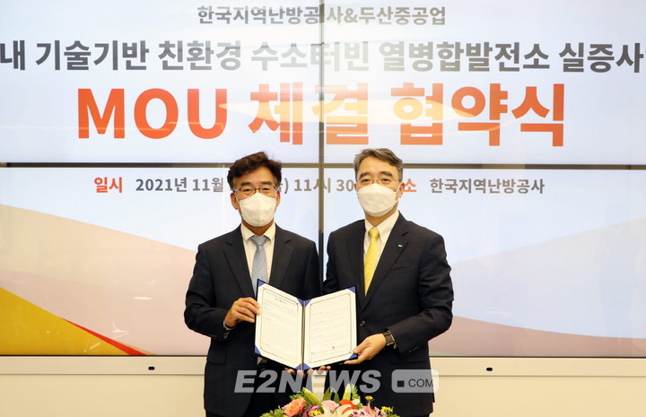▲송현규 한난 안전기술본부장(왼쪽)과 박홍욱 두산중공업 파워서비스 BG장이 수소터빈 기술개발 협약서를 들어보이고 있다.