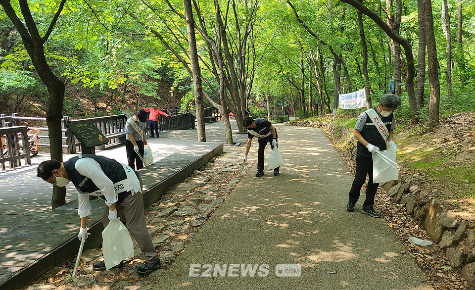 ▲대륜이엔에스 직원들이 수락산 등산로에 버려진 쓰레기를 수거하고 있다.