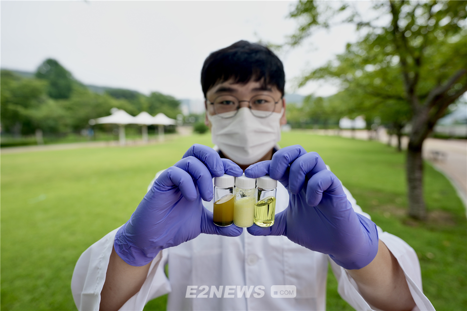 ▲UNIST 연구원이 에탄올 기반 페로브스카이트 용액을 손에 들고 있다.