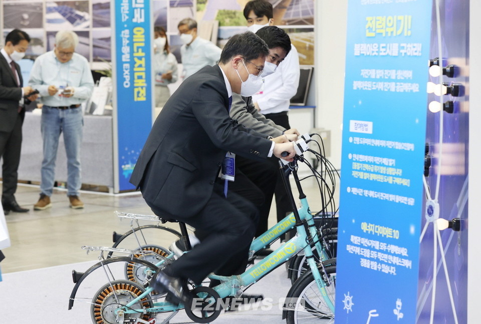 ▲‘2022 대한민국 에너지대전’ 체험 이벤트에서 이상훈 에너지공단 이사장이 자전거 페달을 밟으며 전기를 생산하고 있다.
