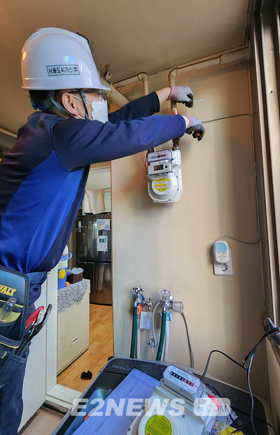 ▲서울도시가스 직원이 수요가에 PLC 전력·가스 통합 원격검침시스템을 설치하고 있다.