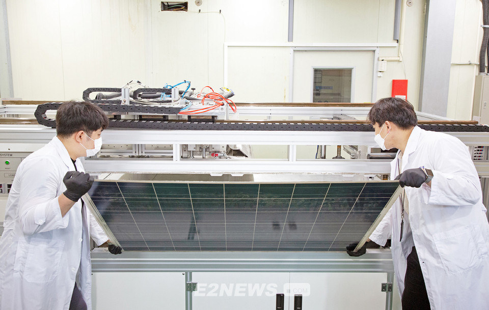 ▲에너지기술연구원 연구원들이 유리를 분리·회수하기 위해 태양광 폐패널을 개발장치에 넣고 있다.
