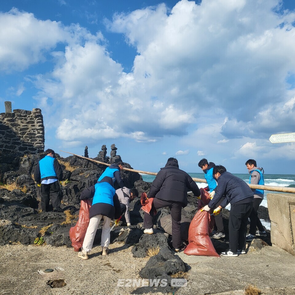 환경정화 활동에 참여한 제주에너지공사와 북촌리새마을회 관계자들이 해양쓰레기를 수거하고 있다.