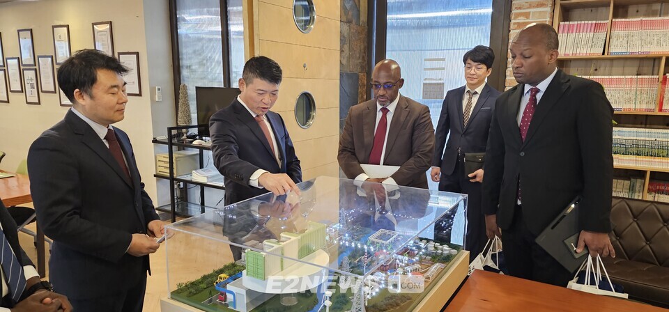 박가우 지필로스 대표(왼쪽 두번째)가 바쿠라무챠 은쿠비토 만지 주한르완다 대사(왼쪽 세번째)에게 모형을 통해 그린수소 생산 P2G시스템을 설명하고 있다.