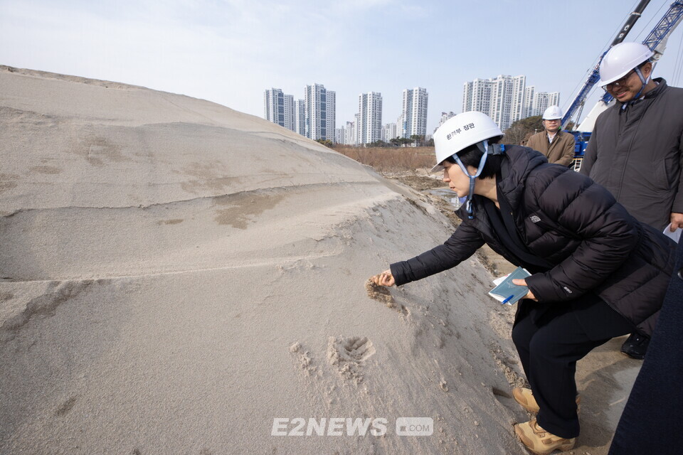 한화진 장관이 세종보 상류에 쌓여있던 모래를 만져보고 있다.
