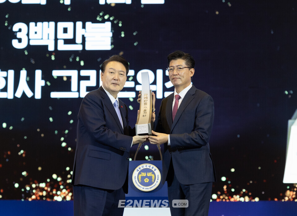 김구환 그리드위즈 대표(오른쪽)가 무역의날 기념식에서 윤석열 대통령으로부터 수출탑 300만불 달성패를 받고 있다.