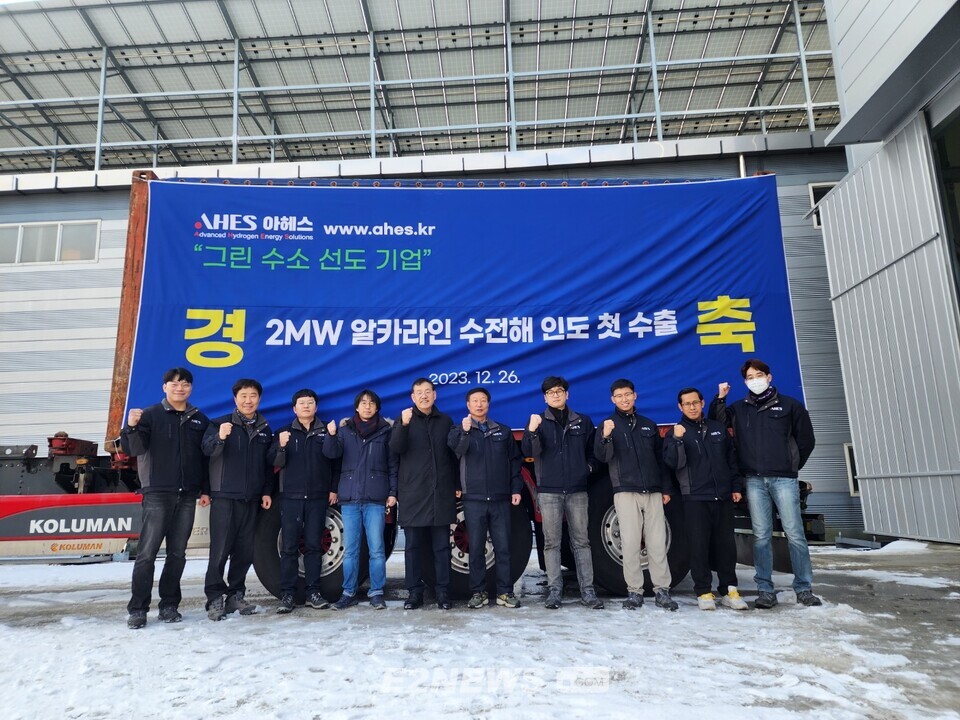 김남훈(왼쪽 4번째), 이중희(왼쪽 5번째) 아헤스 공동대표가 2MW 알칼라인 수전해 해외 첫 수출 기념식에서 임직원들과 파이팅 포즈를 취하고 있다.