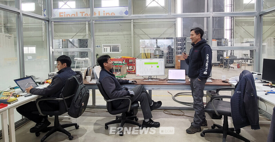 (오른쪽 첫번째) 김용철 ESS솔루션사업부장(상무이사)이 음성공장 내부에 마련된 투명보드 사무실에서 엔지니어들과 제품개발회의를 하고 있다.