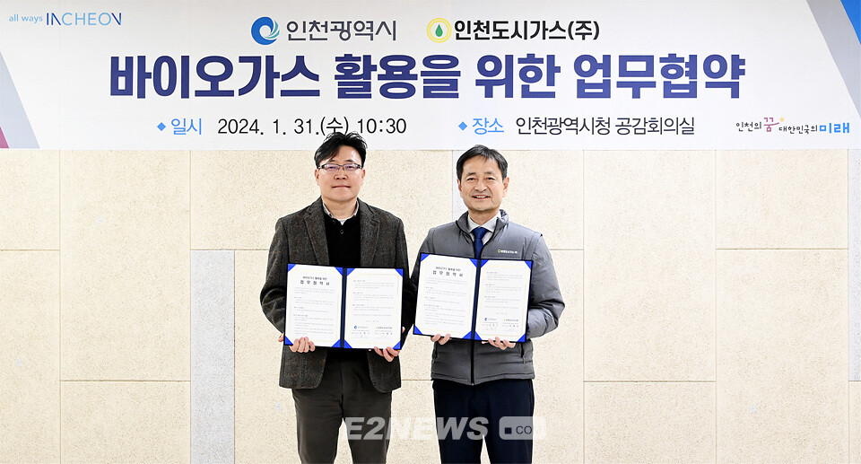 김철수 인천시 환경국장과 이재상 인천도시가스 전무이사가 체결한 협약서를 보이며 협력을 다짐하고 있다.