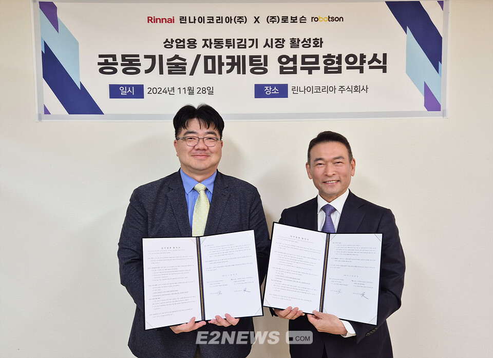 강상규 린나이 영업본부장(왼쪽)과 강인각 로보슨 대표이사가 체결한 협약서를 보이며 협력을 다짐하고 있다.