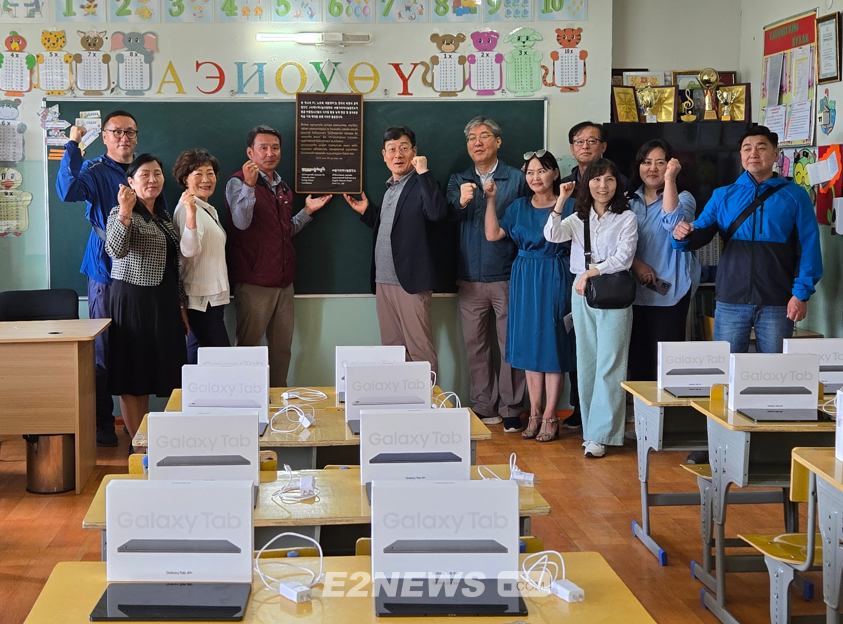 에너지나눔과평화가 지원한 태블릿PC가 설치돼 있는 몽골 젠클학교 컴퓨터실에서 단체와 학교 관계자들이 현판을 들고 기념촬영을 하고 있다.